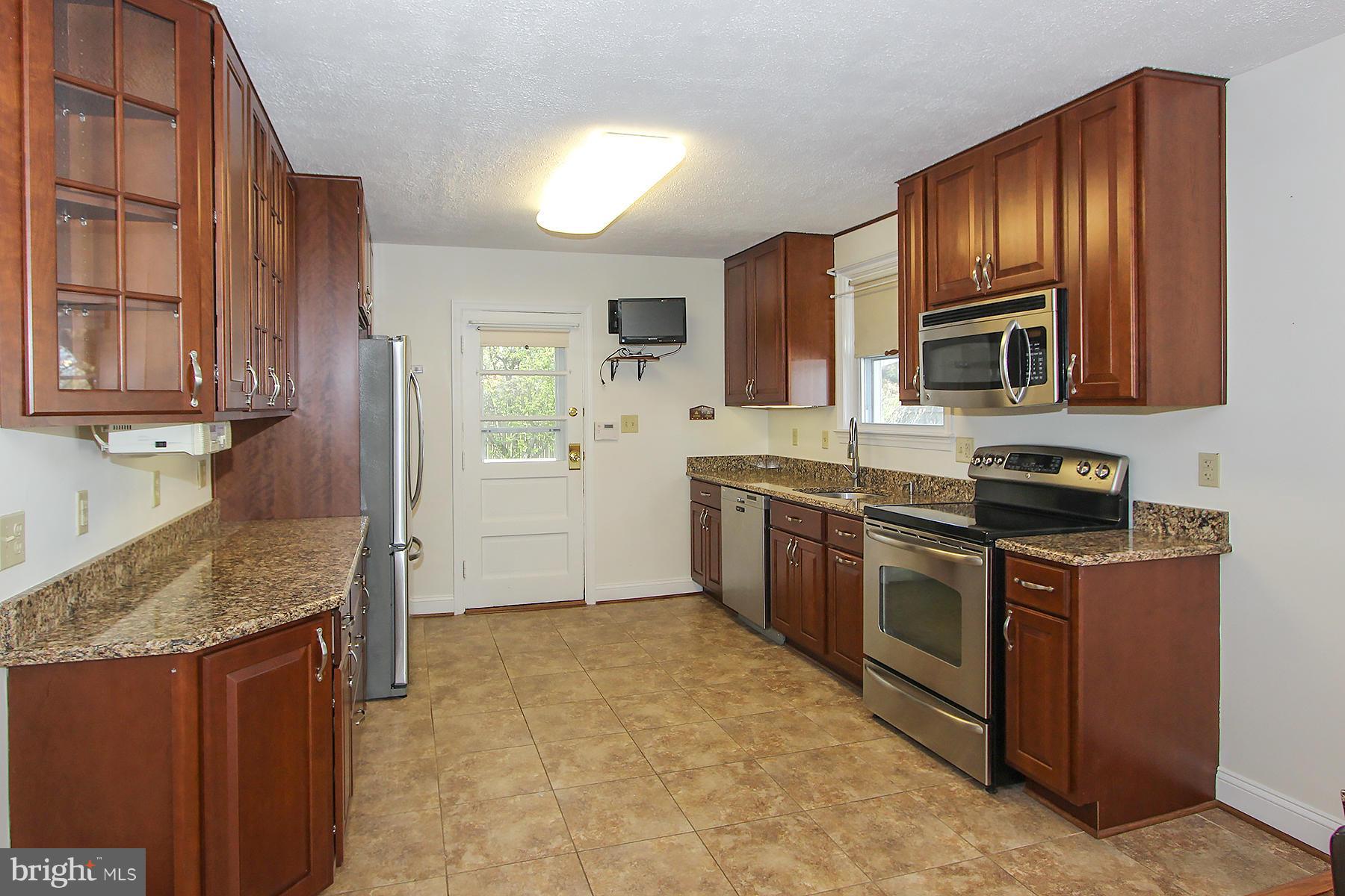20820 Slidell Road Boyds, MD 20841 - Photo 6 of 29 a kitchen with granite countertop wooden cabinets stainless steel appliances and a counter space