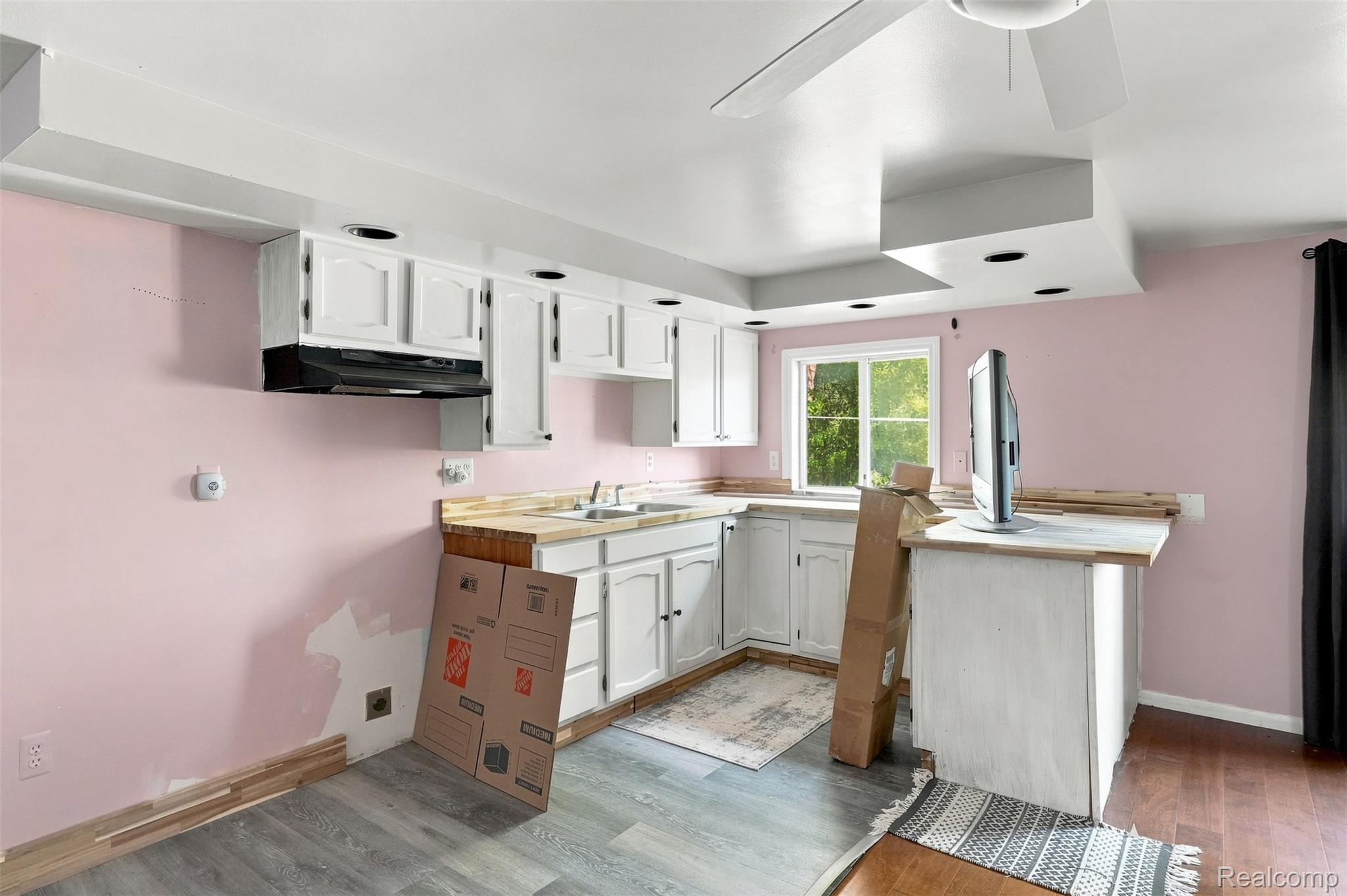 5161 Parker Road Fort Gratiot, MI 48059 - Photo 47 of 64 Kitchen featuring white cabinetry, stainless steel appliances, wood-finish countertops, and pink accent walls