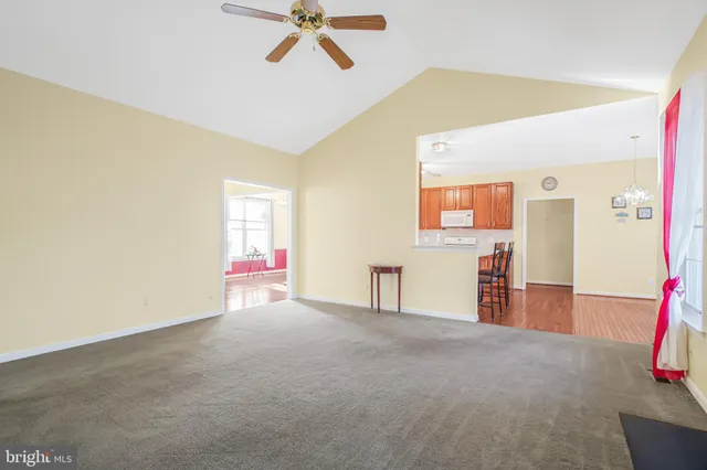 a view of a livingroom with wooden floor and a ceiling fan