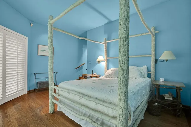 a bedroom with a bed and a lamp on the dresser