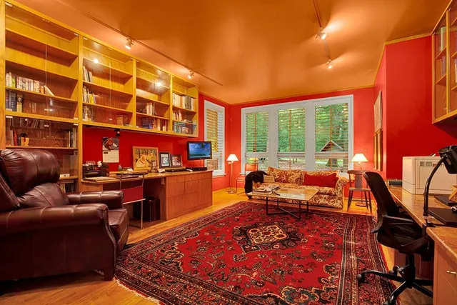 a living room with furniture a rug and a floor to ceiling window