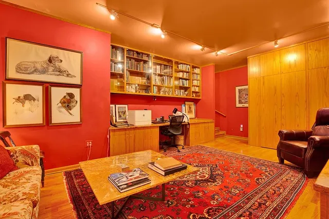 a living room with furniture a rug and a wall painting