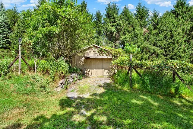 a large stone house with a big yard and large trees