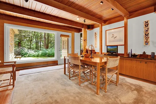 a dining room with furniture and a large window