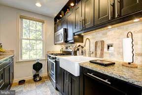 2719 Ordway Street Northwest, Unit 6 Washington, DC 20008 - Photo 6 of 12 a kitchen with stainless steel appliances granite countertop a sink stove and refrigerator
