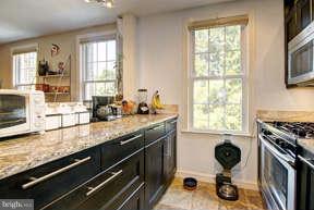 2719 Ordway Street Northwest, Unit 6 Washington, DC 20008 - Photo 7 of 12 a kitchen with granite countertop stainless steel appliances a stove sink and microwave