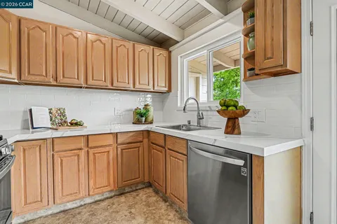 a kitchen with stainless steel appliances granite countertop a sink a stove and a cabinets