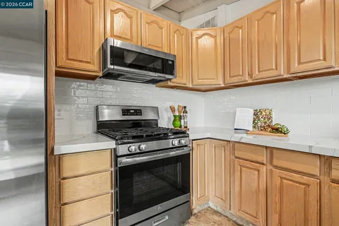 a kitchen with stainless steel appliances granite countertop a stove microwave and cabinets