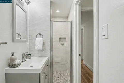 a bathroom with a sink vanity granite shower and a mirror