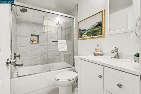 a bathroom with a granite countertop sink toilet and shower