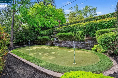 a view of a swimming pool with a bench and trees in the background