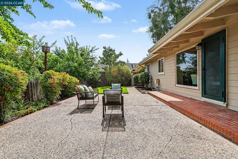 a view of a patio with a table and chairs under an umbrella