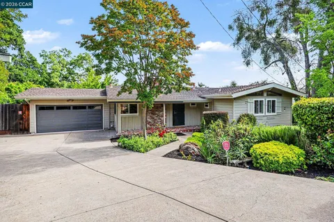 front view of a house with a yard and potted plants