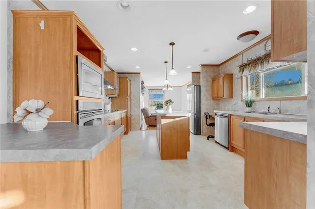 a large kitchen with stainless steel appliances granite countertop a lot of counter space and wooden floor