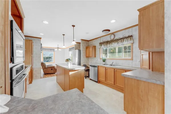 a kitchen with stainless steel appliances granite countertop a refrigerator a oven and a sink
