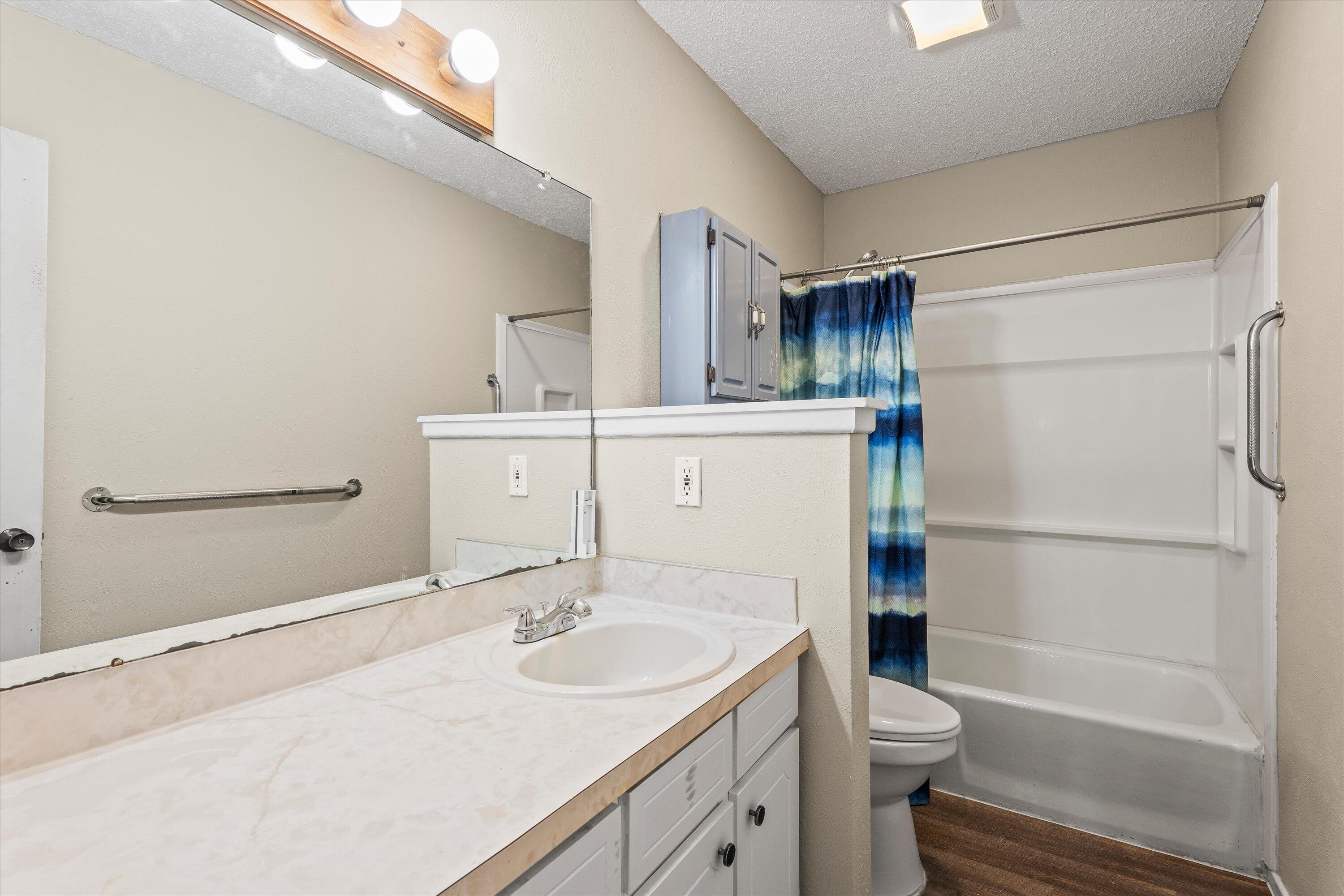 4520 54th Street Lubbock, TX 79414 - Photo 21 of 32 a bathroom with a sink toilet vanity and shower
