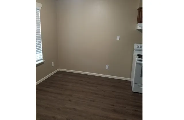 a view of an empty room with wooden floor
