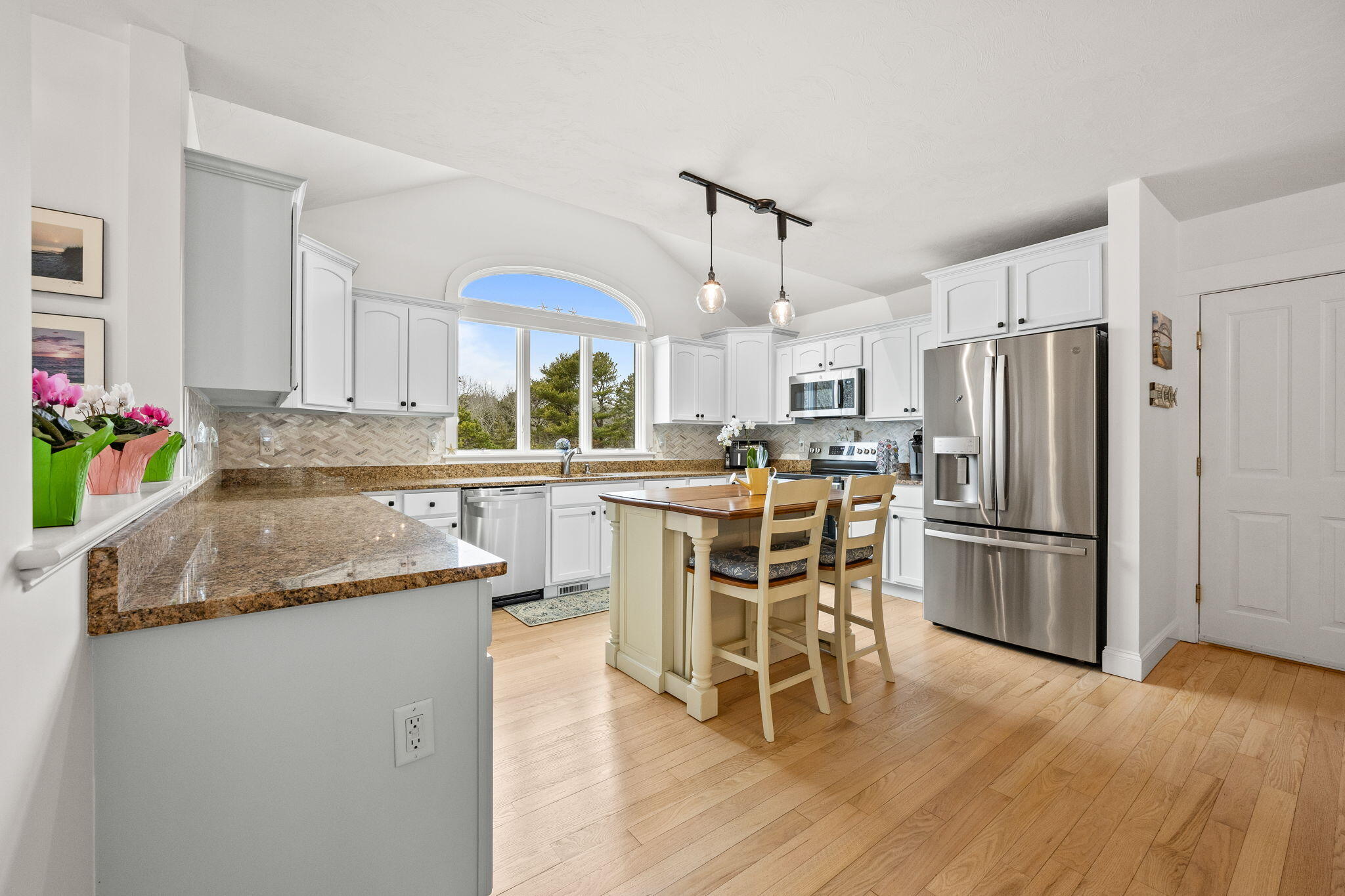 11 Aspen Road Buzzards Bay, MA 02532 - Photo 10 of 43 a kitchen with stainless steel appliances granite countertop a refrigerator a sink a stove a dining table and chairs with wooden floor