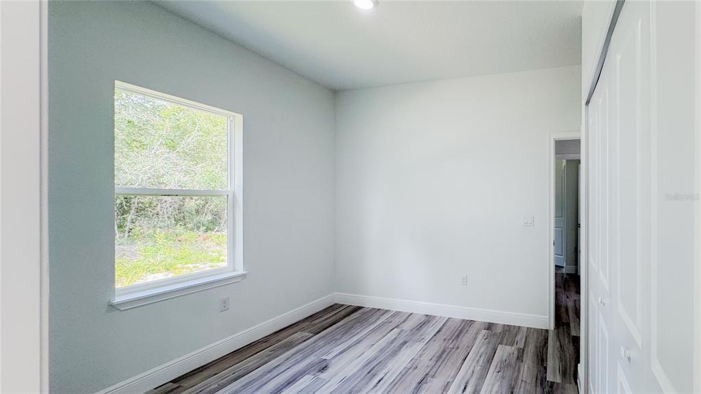 15625 Southwest 37th Circle Ocala, FL 34473 - Photo 16 of 27 a view of an empty room with wooden floor and a window