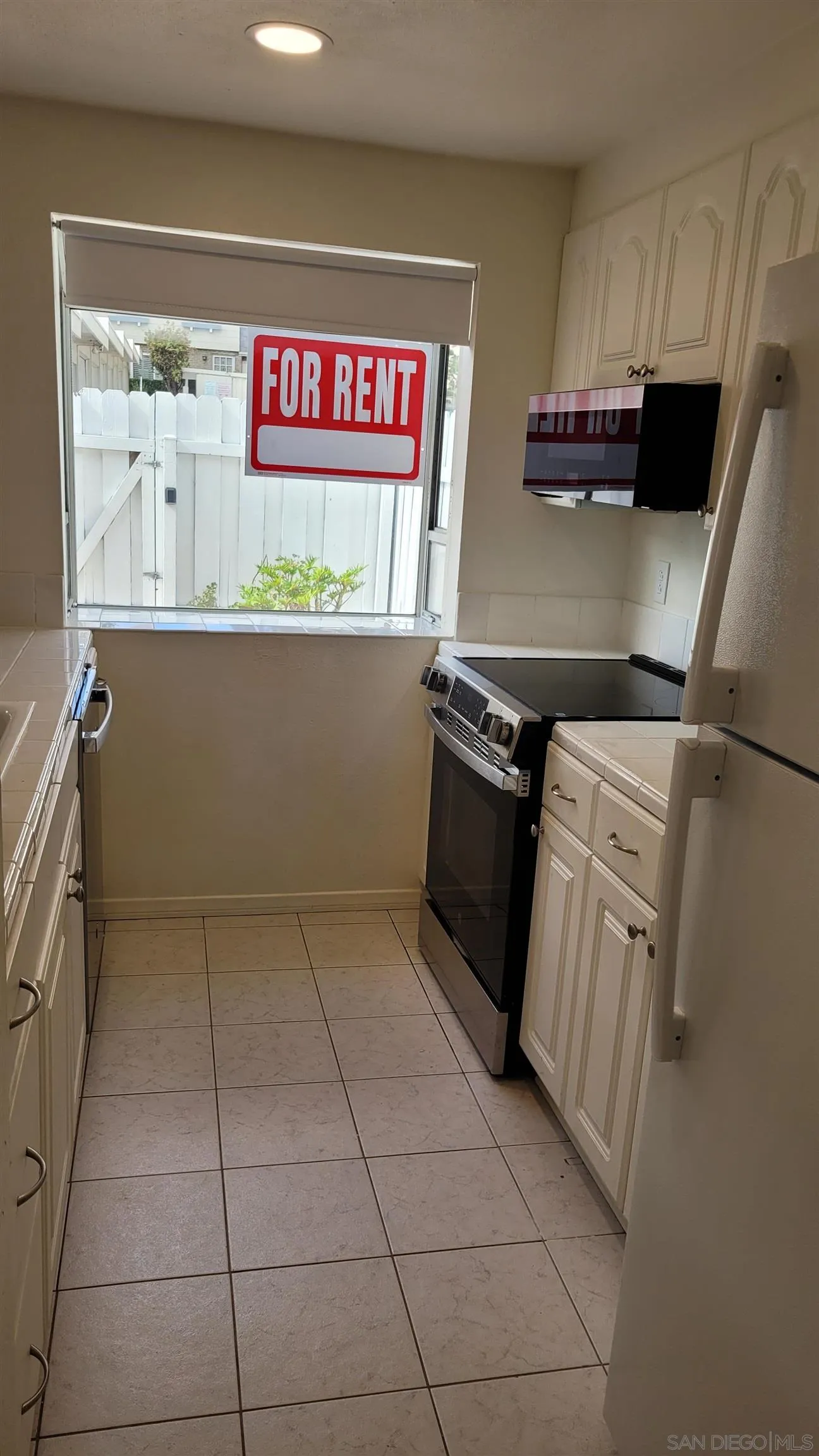 863 Del Mar Downs Road, Unit D Solana Beach, CA 92075 - Photo 11 of 23 a kitchen with kitchen island a stove a refrigerator a sink and dishwasher