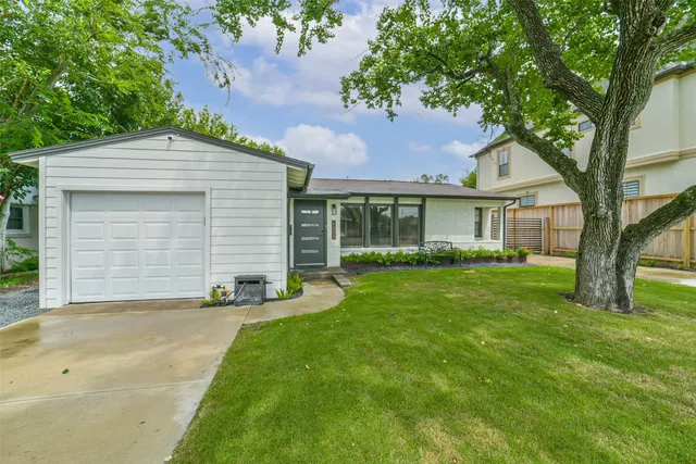 a front view of a house with a garden and yard