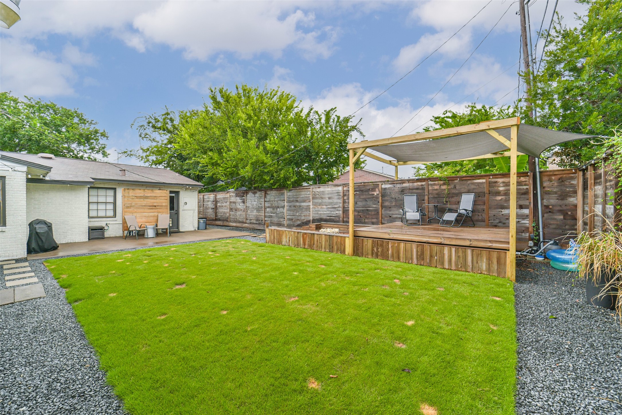 6205 South Rice Avenue Bellaire, TX 77401 - Photo 17 of 21 a backyard of a house with table and chairs under an umbrella
