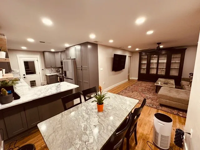 a kitchen with kitchen island granite countertop a sink and a refrigerator