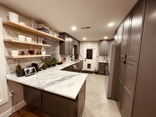 6205 South Rice Avenue Bellaire, TX 77401 - Photo 5 of 21 a kitchen with stainless steel appliances kitchen island granite countertop a refrigerator a sink a stove and island