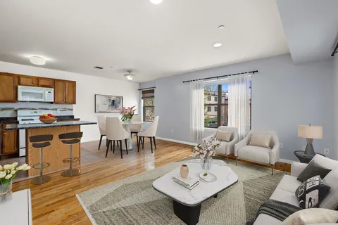 a living room with furniture kitchen view and a window
