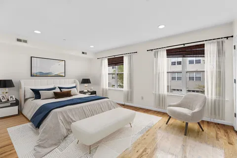 a bedroom with a large bed and a chair