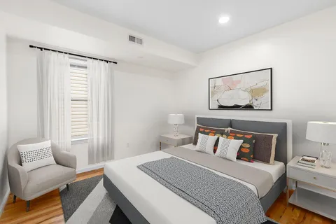a bedroom with a bed and wooden floor