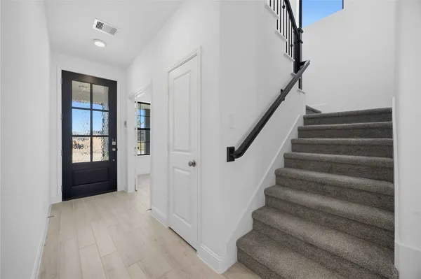 a view of an entryway with wooden floor and stairs