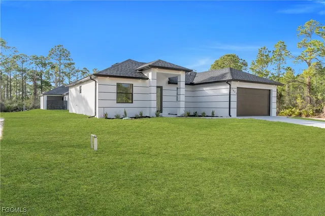 a front view of house with yard and trees in the background