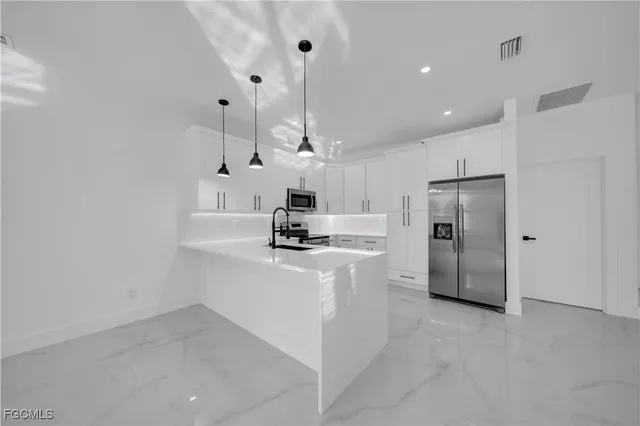 a kitchen with stainless steel appliances a refrigerator sink and stove