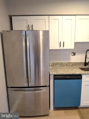 a view of a kitchen with a sink and a refrigerator