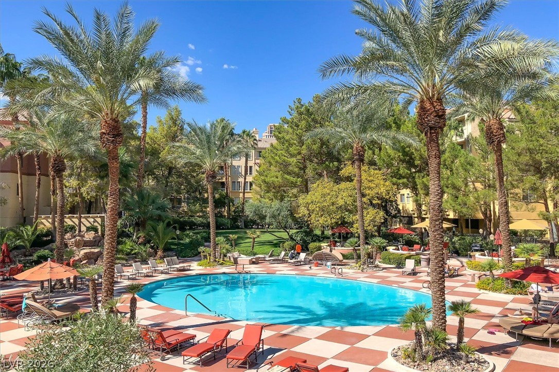 220 East Flamingo Road, Unit 305 Las Vegas, NV 89169 - Photo 17 of 26 A refreshing pool awaits, surrounded by mature palm trees and ample lounging space.