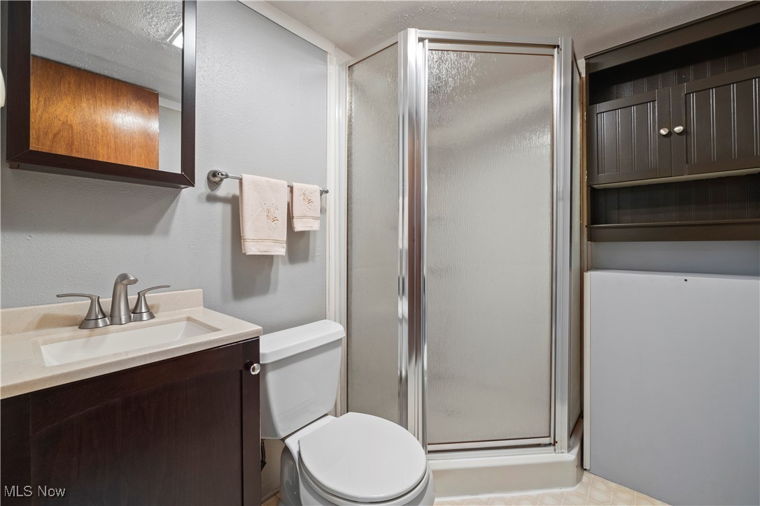 20114 Drake Road Strongsville, OH 44149 - Photo 25 of 35 Bathroom with a stall shower, vanity, and a textured ceiling