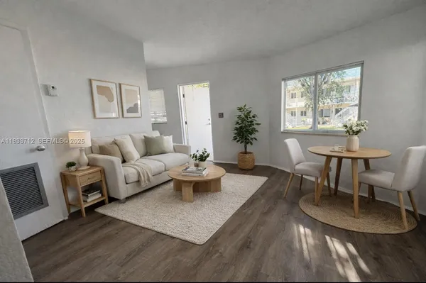 a living room with furniture a large window and a table
