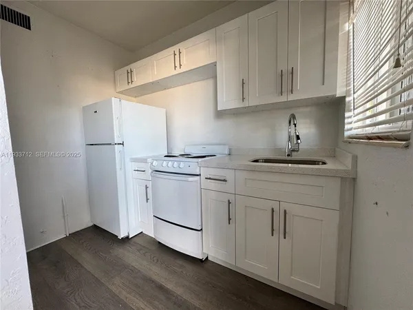 a kitchen with white cabinets and white appliances