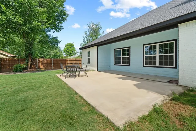 a view of green field with trees in the background