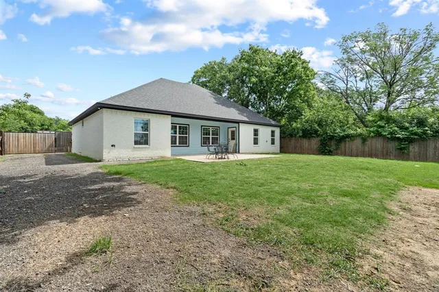 a view of backyard with wooden fence