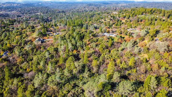 an aerial view of residential house with green space and fog
