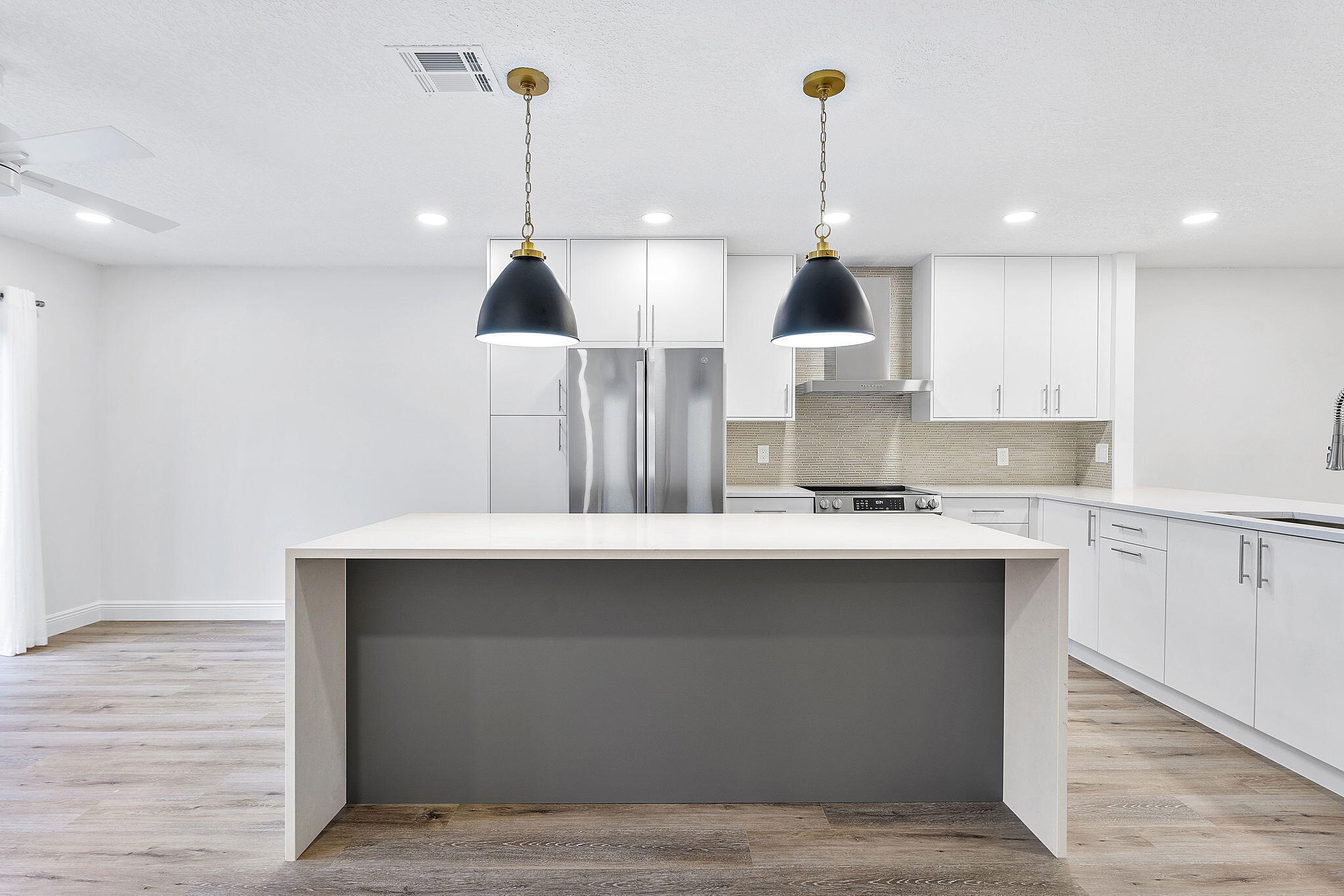 9180 Pine Springs Drive Boca Raton, FL 33428 - Photo 1 of 29 a kitchen with kitchen island a sink stainless steel appliances and cabinets