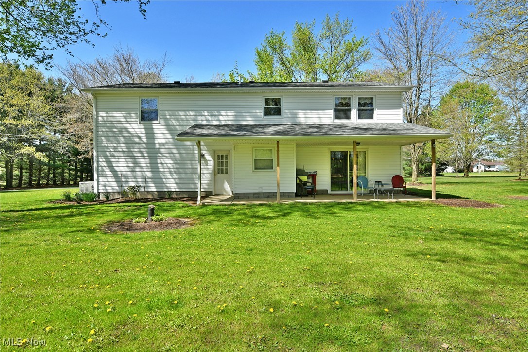 379 Housel Craft Road Bristolville, OH 44402 - Photo 7 of 50 Rear view of house with a lawn and a patio area