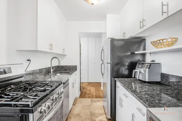a kitchen with stainless steel appliances granite countertop a sink stove and refrigerator