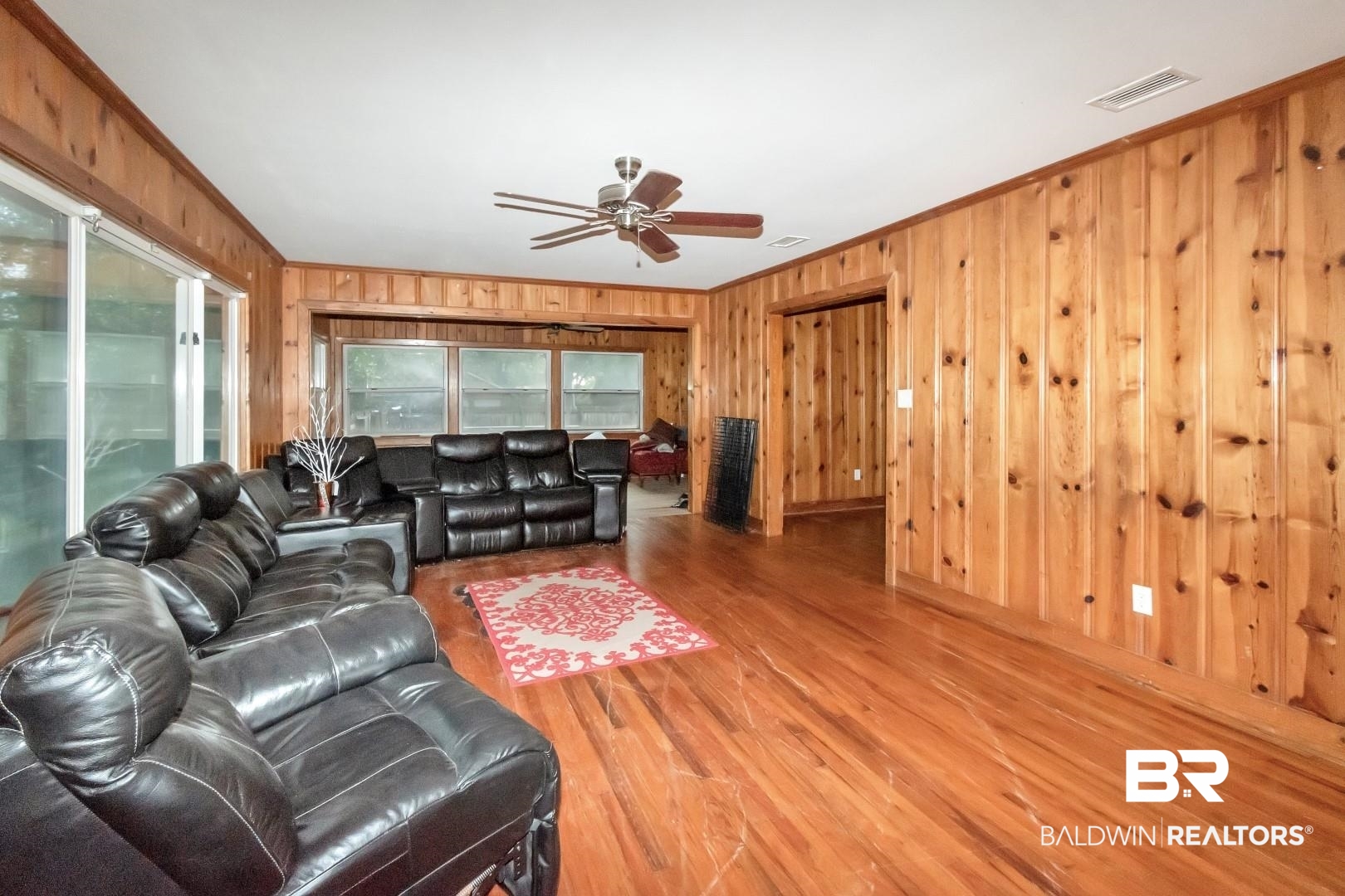 2762 Hillcrest Road Mobile, AL 36695 - Photo 8 of 25 Living room with ceiling fan, wooden walls, wood-type flooring, and ornamental molding
