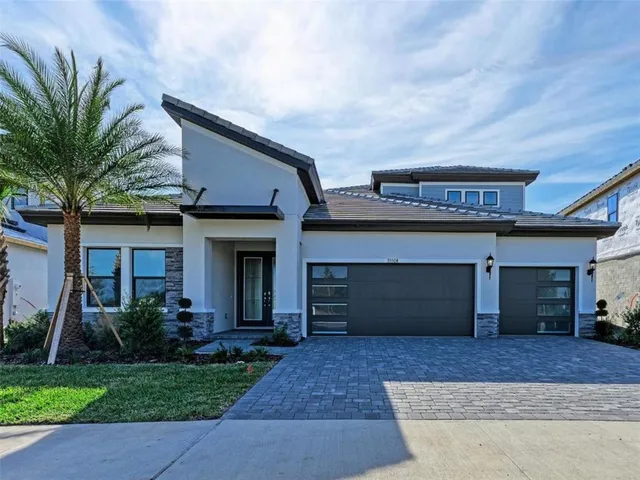 a front view of a house with a garden and garage