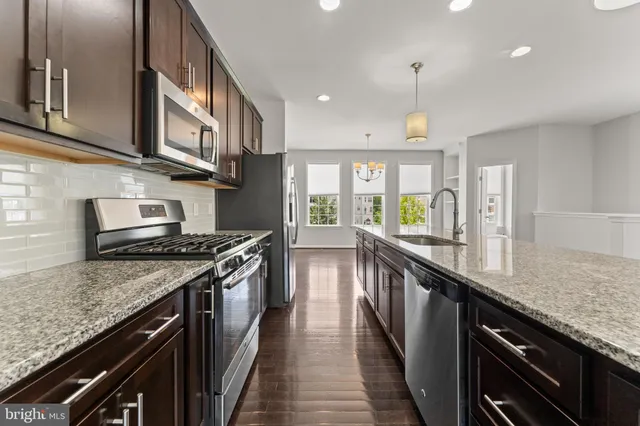 a kitchen with stainless steel appliances granite countertop a stove and a sink