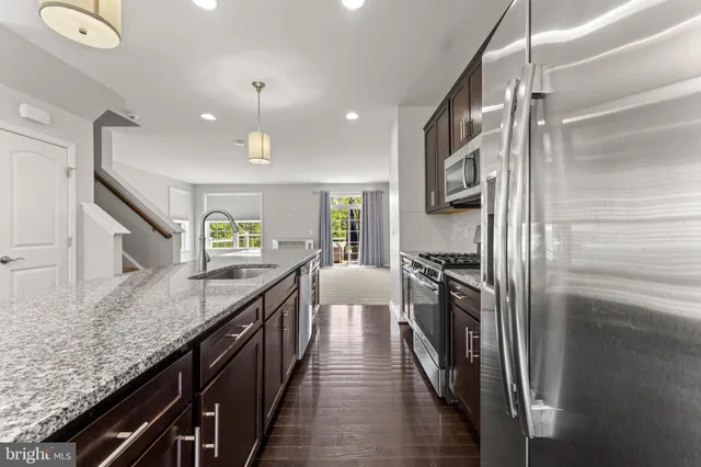 a kitchen with stainless steel appliances granite countertop lots of counter top space and wooden floor