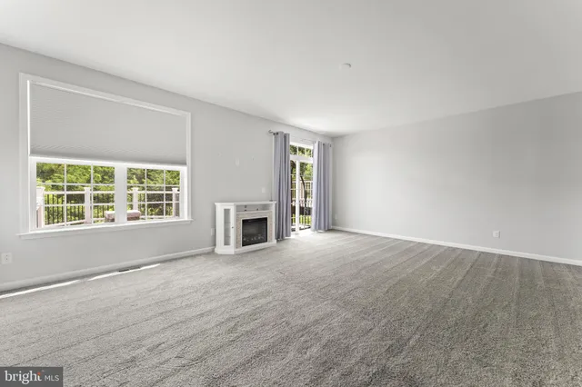 wooden floor fireplace and windows in an empty room